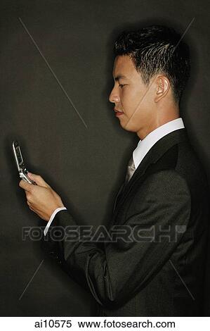 Stock Photography - Young man using mobile phone, text messaging. Fotosearch