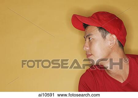 Young man wearing a red cap, against a yellow background View Large Photo Image Stock Image - Young man wearing a red cap, against a yellow background. Fotosearch