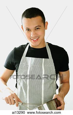 Young man wearing apron and holding whisk and pan View Large Photo Image Stock Image - Young man wearing apron and holding whisk and pan. Fotosearch