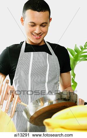 Young man wearing apron, cooking View Large Photo Image Stock Image - Young man wearing apron, cooking. Fotosearch