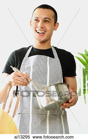 Young man wearing apron, stirring saucepan with whisk View Large Photo Image Stock Photography - Young man wearing apron, stirring saucepan with whisk. Fotosearch