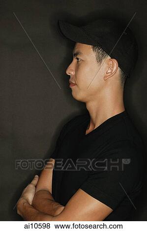 Young man with arms crossed, black background View Large Photo Image Stock Photo - Young man with arms crossed, black background. Fotosearch