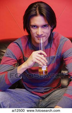 Young man with beer bottle, looking at camera View Large Photo Image Stock Image - Young man with beer bottle, looking at camera. Fotosearch