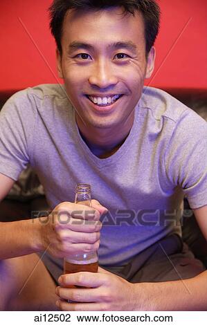 Young man with beer bottle, looking at camera View Large Photo Image Stock Image - Young man with beer bottle, looking at camera. Fotosearch