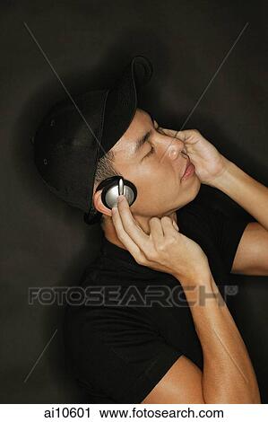 Young man with headphones, black background View Large Photo Image Stock Image - Young man with headphones, black background. Fotosearch