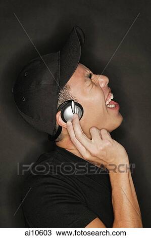 Young man with headphones, black background View Large Photo Image Stock Image - Young man with headphones, black background. Fotosearch