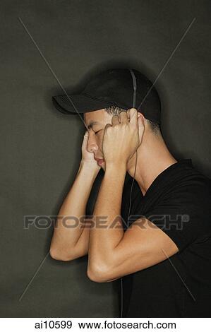 Young man with headphones, black background View Large Photo Image Stock Photo - Young man with headphones, black background. Fotosearch