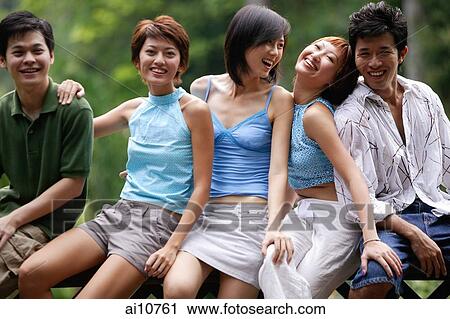 Young men and women sitting side by side, looking at camera View Large Photo Image Stock Image - Young men and women sitting side by side, looking at camera. Fotosearch