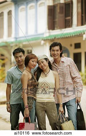 Stock Photograph - Young men and women standing, looking at camera. Fotosearch