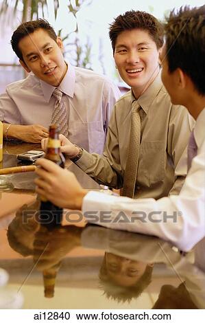 Young men at bar counter talking View Large Photo Image Stock Image - Young men at bar counter talking. Fotosearch