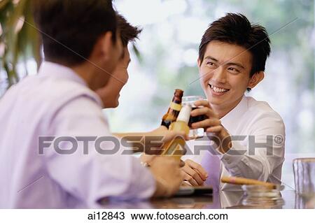 Young men at bar counter toasting with drinks View Large Photo Image Stock Image - Young men at bar counter toasting with drinks. Fotosearch