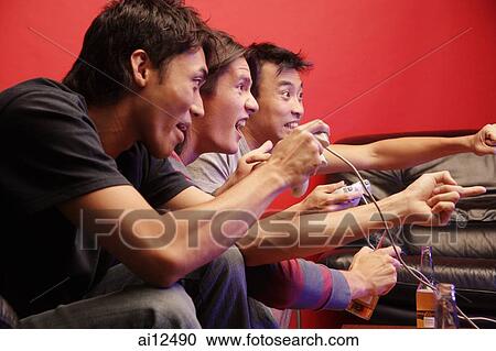Young men holding video game controllers, making hand signs View Large Photo Image Stock Image - Young men holding video game controllers, making hand signs. Fotosearch
