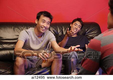 Young men sitting on sofa, with beer bottles View Large Photo Image Stock Photography - Young men sitting on sofa, with beer bottles. Fotosearch