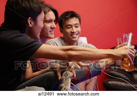 Young men toasting with beer bottles View Large Photo Image Stock Image - Young men toasting with beer bottles. Fotosearch