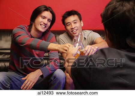 Young men toasting with beer bottles, face to face View Large Photo Image Stock Image - Young men toasting with beer bottles, face to face. Fotosearch