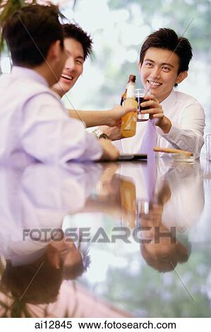 Young men with drinks, toasting View Large Photo Image Stock Photography - Young men with drinks, toasting. Fotosearch