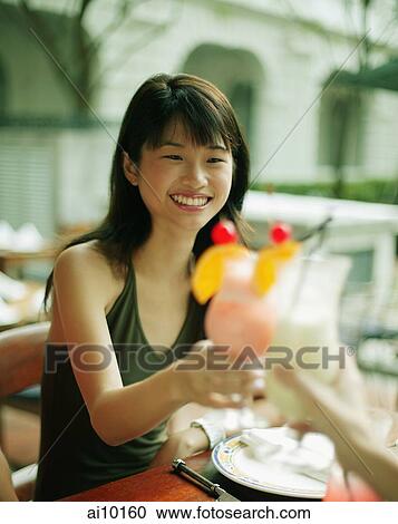 Young woman and friend toasting with drinks. View Large Photo Image Stock Image - Young woman and friend toasting with drinks.. Fotosearch