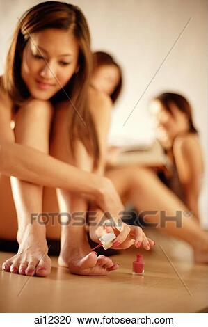 Young woman applying nail polish, friends in the background View Large Photo Image Stock Image - Young woman applying nail polish, friends in the background. Fotosearch