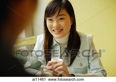 Young woman at a cafe, man in front of her View Large Photo Image Stock Image - Young woman at a cafe, man in front of her. Fotosearch