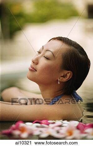 Young woman, at edge of swimming pool, head tilted up. View Large Photo Image Stock Image - Young woman, at edge of swimming pool, head tilted up.. Fotosearch