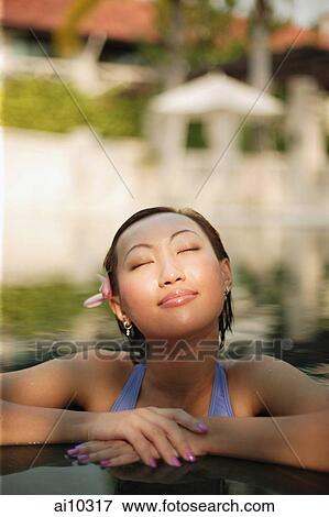 Young woman, at edge of swimming pool, eyes closed View Large Photo Image Stock Photo - Young woman, at edge of swimming pool, eyes closed. Fotosearch