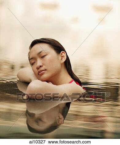 Young woman, at edge of swimming pool, eyes closed View Large Photo Image Stock Photo - Young woman, at edge of swimming pool, eyes closed. Fotosearch