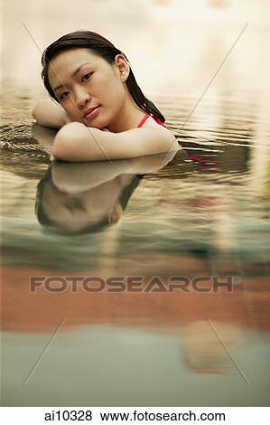 Young woman, at edge of swimming pool, looking at camera View Large Photo Image Stock Photo - Young woman, at edge of swimming pool, looking at camera. Fotosearch