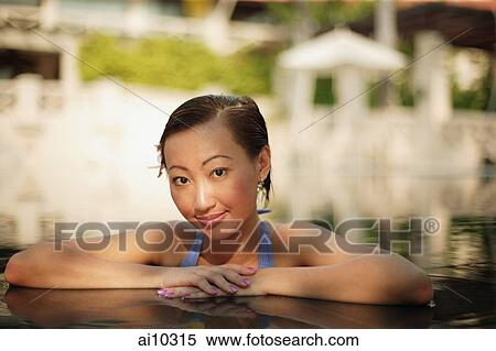 Young woman at the edge of a pool, looking at camera View Large Photo Image Stock Photography - Young woman at the edge of a pool, looking at camera. Fotosearch