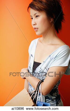 Stock Photograph - Young woman carrying shopping bags. Fotosearch