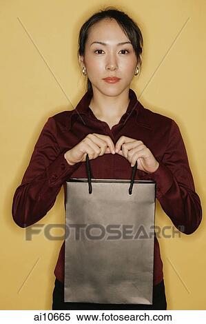 Young woman carrying shopping bags, yellow background View Large Photo Image Stock Photography - Young woman carrying shopping bags, yellow background. Fotosearch
