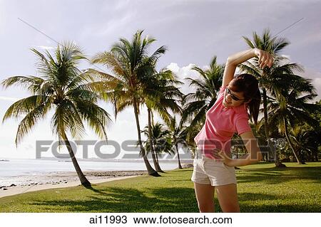 Young woman doing stretching exercises in park View Large Photo Image Stock Image - Young woman doing stretching exercises in park. Fotosearch