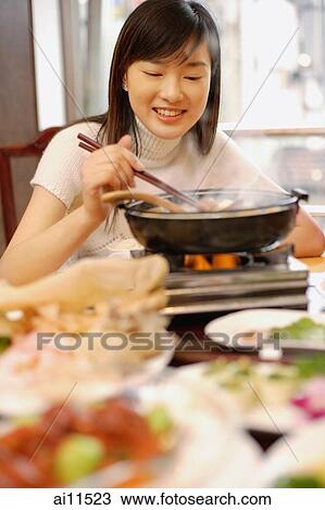 Young woman eating at Chinese restaurant. View Large Photo Image Stock Image - Young woman eating at Chinese restaurant.. Fotosearch