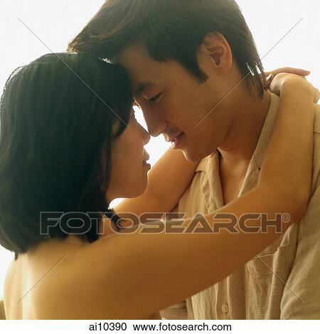 Stock Image - Young woman embracing young man. Fotosearch