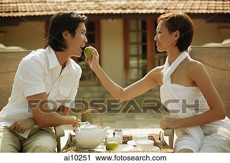 Stock Image - Young woman feeding young man.. Fotosearch