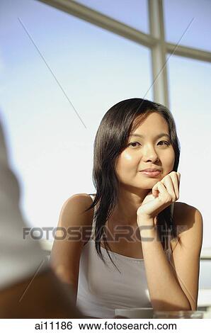 Young woman, hands on chin, looking at camera View Large Photo Image Stock Photograph - Young woman, hands on chin, looking at camera. Fotosearch