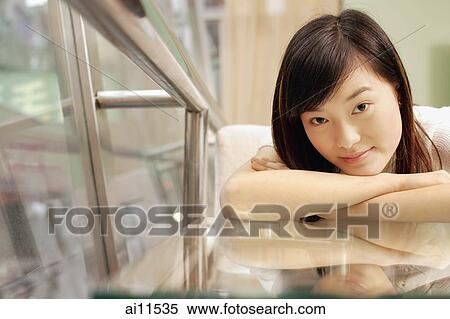 Stock Photography - Young woman, head on crossed arms, looking at camera. Fotosearch