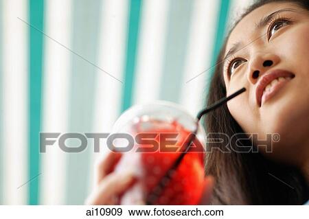 Young woman holding a drink View Large Photo Image Stock Photo - Young woman holding a drink. Fotosearch