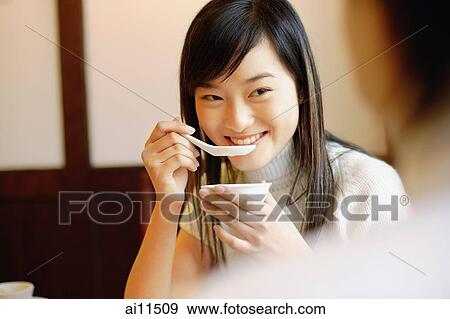 Young woman holding bowl, eating soup View Large Photo Image Stock Photo - Young woman holding bowl, eating soup. Fotosearch