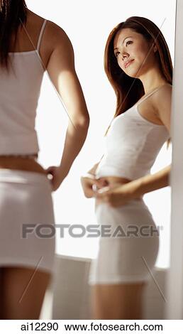 Young woman holding measuring tape around her waist View Large Photo Image Stock Image - Young woman holding measuring tape around her waist. Fotosearch