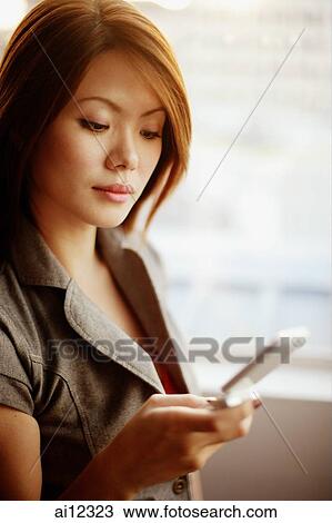 Young woman holding mobile phone View Large Photo Image Stock Image - Young woman holding mobile phone. Fotosearch