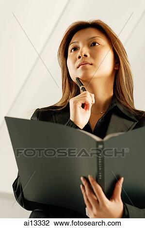 Stock Image - Young woman, holding pen and file. Fotosearch