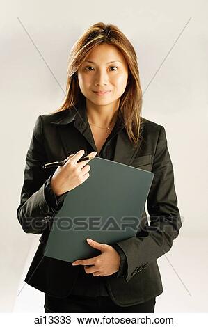 Young woman, holding pen and file, looking at camera View Large Photo Image Stock Image - Young woman, holding pen and file, looking at camera. Fotosearch