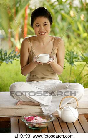 Young woman holding teacup, portrait View Large Photo Image Stock Image - Young woman holding teacup, portrait. Fotosearch