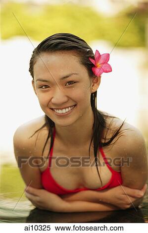 Young woman in a swimming pool, flower in hair View Large Photo Image Stock Photography - Young woman in a swimming pool, flower in hair. Fotosearch