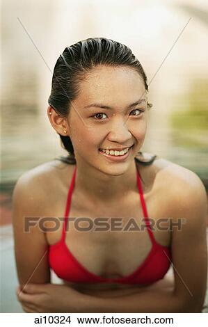 Young woman in a swimming pool, smiling View Large Photo Image Picture - Young woman in a swimming pool, smiling. Fotosearch