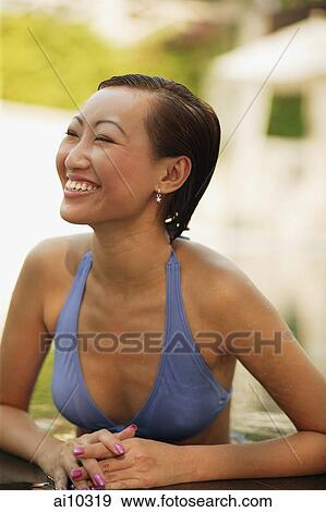 Stock Photo - Young woman in a swimming pool, smiling. Fotosearch