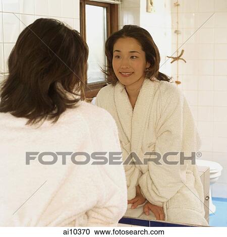Young woman in bathrobe, looking at mirror View Large Photo Image Stock Image - Young woman in bathrobe, looking at mirror. Fotosearch
