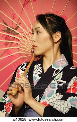 Young woman in kimono, holding an umbrella View Large Photo Image Stock Photo - Young woman in kimono, holding an umbrella. Fotosearch