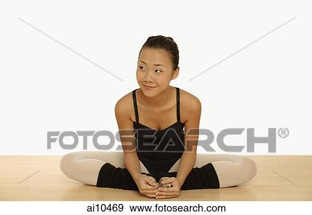Stock Photo - Young woman in leotard sitting with legs folded.. Fotosearch
