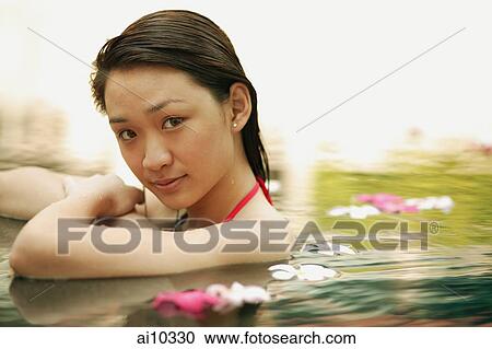 Young woman in swimming pool, looking at camera View Large Photo Image Stock Image - Young woman in swimming pool, looking at camera. Fotosearch